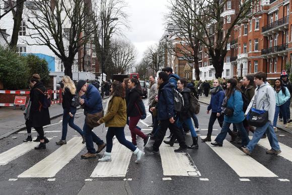 Fãs dos Beatles cruzaram a famosa faixa de pedestre em frente ao Abbey Road Studios, em homenagem ao produtor musical George Martin, conhecido como o quinto Beatle