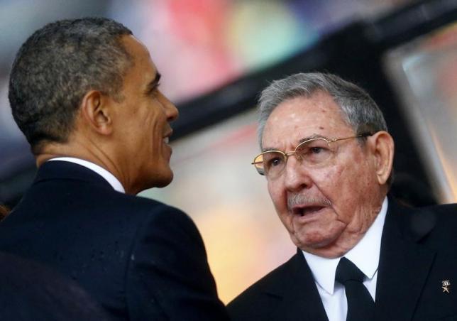 U.S. President Barack Obama (L) greets Cuban President Raul Castro before giving his speech at the memorial service for late South African President Nelson Mandela at the First National Bank soccer stadium, also known as Soccer City, in Johannesburg December 10, 2013. REUTERS/Kai Pfaffenbach