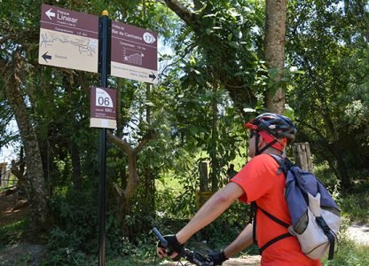 Ciclista observa placas instaladas nas trilhas de Joaquim Egídio